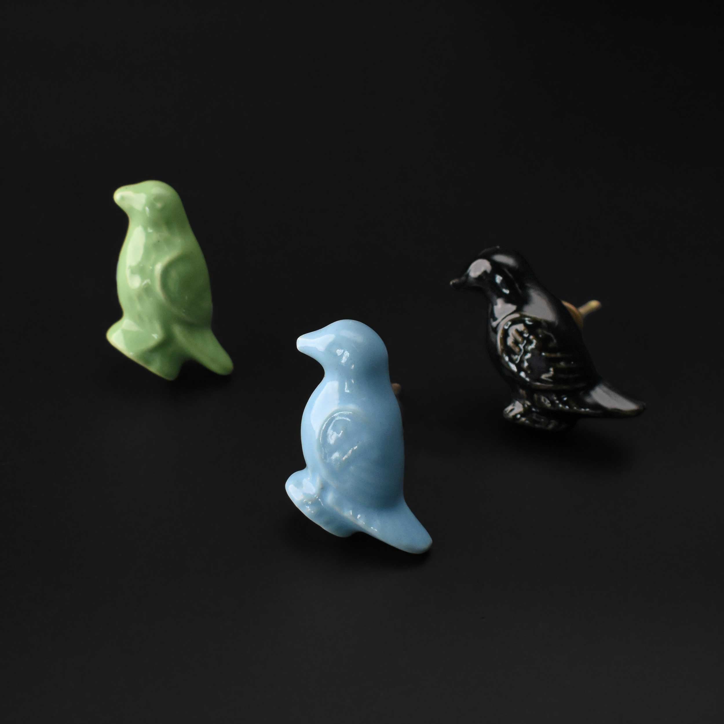ceramic bird knobs in green, blue, and black.